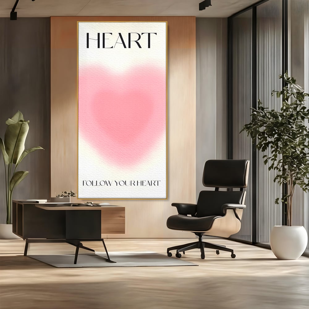 Tablou canvas cu tablou vertical cu inima roz blurata, in rama de aluminiu auriu, pe perete intr-un birou